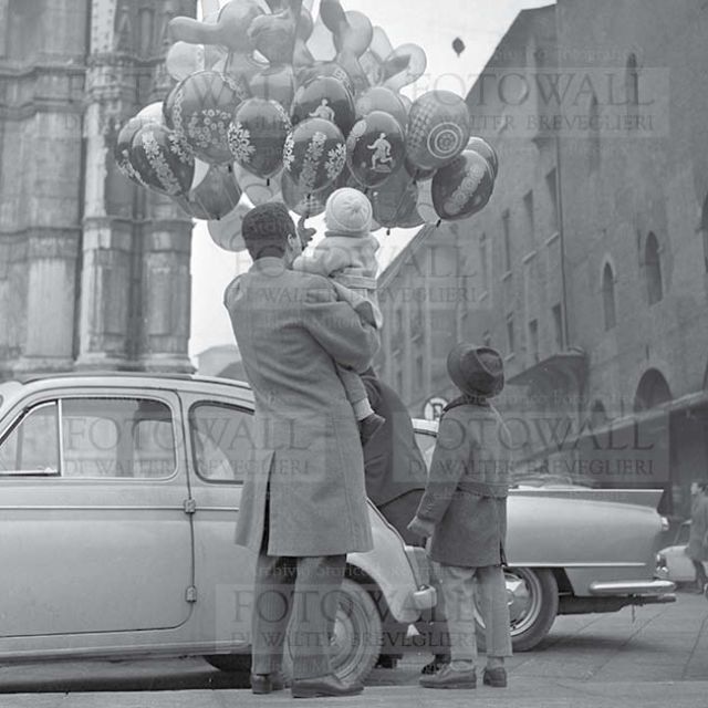 Papà e figli dal venditore di palloncini